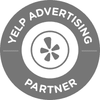 Gray circular badge with the Yelp logo in the center. The words "Yelp Advertising Partner" are written in a ring around the outside—perfect for an SEO Company NYC, NY, or Search Engine Optimization Company Long Island to showcase credibility.