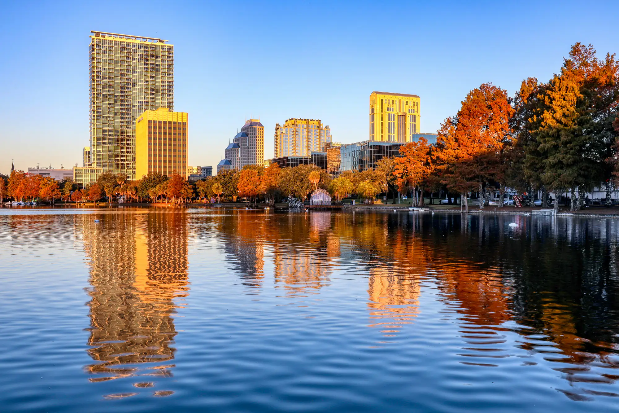 City skyscrapers and autumn trees reflect in a calm lake at sunset in NYC, home to top SEO Company NYC.